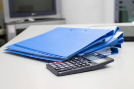 file-folder-with-documents-and-calculator-on-table-in-meeting-room